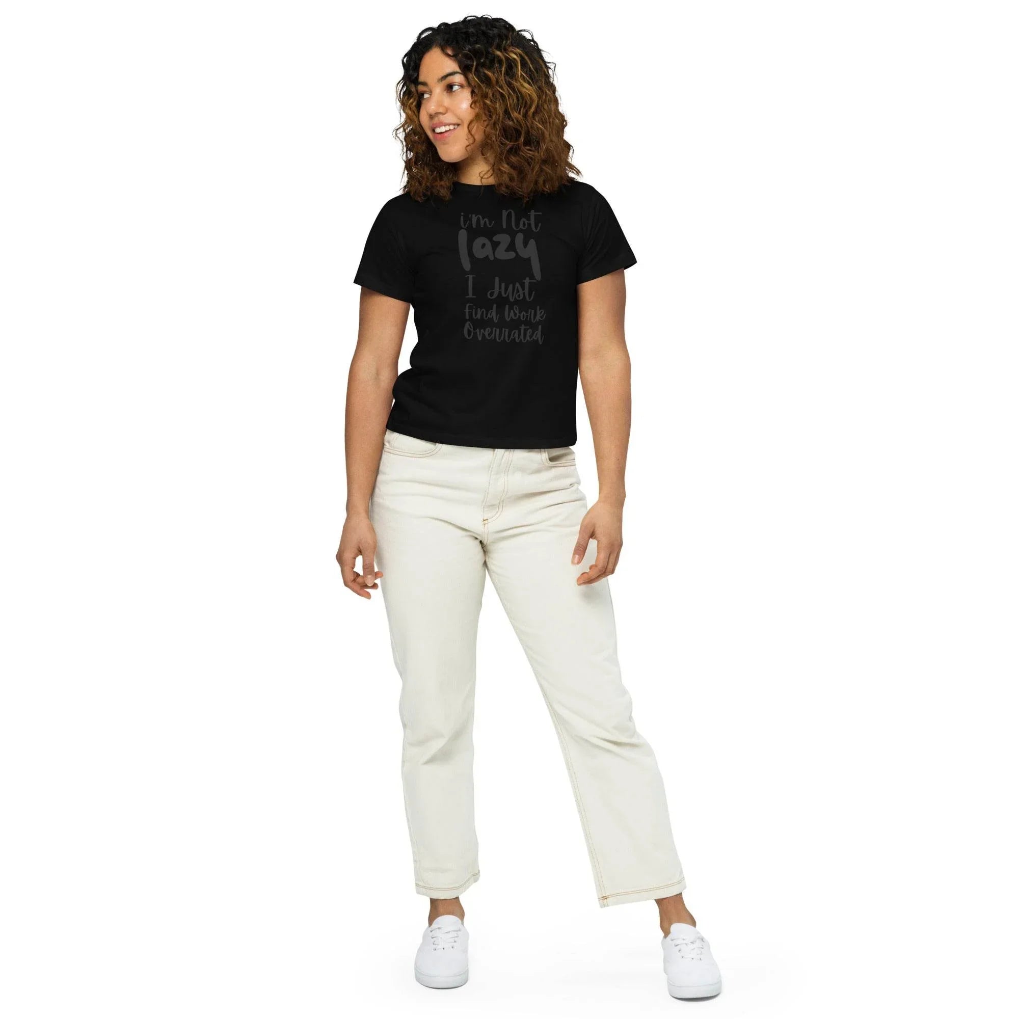 Woman wearing a black cropped graphic t-shirt with the phrase ‘I’m Not Lazy, I Just Need More Energy,’ paired with cream pants — part of the Cropped & Chic Tops collection. - Annaise Store